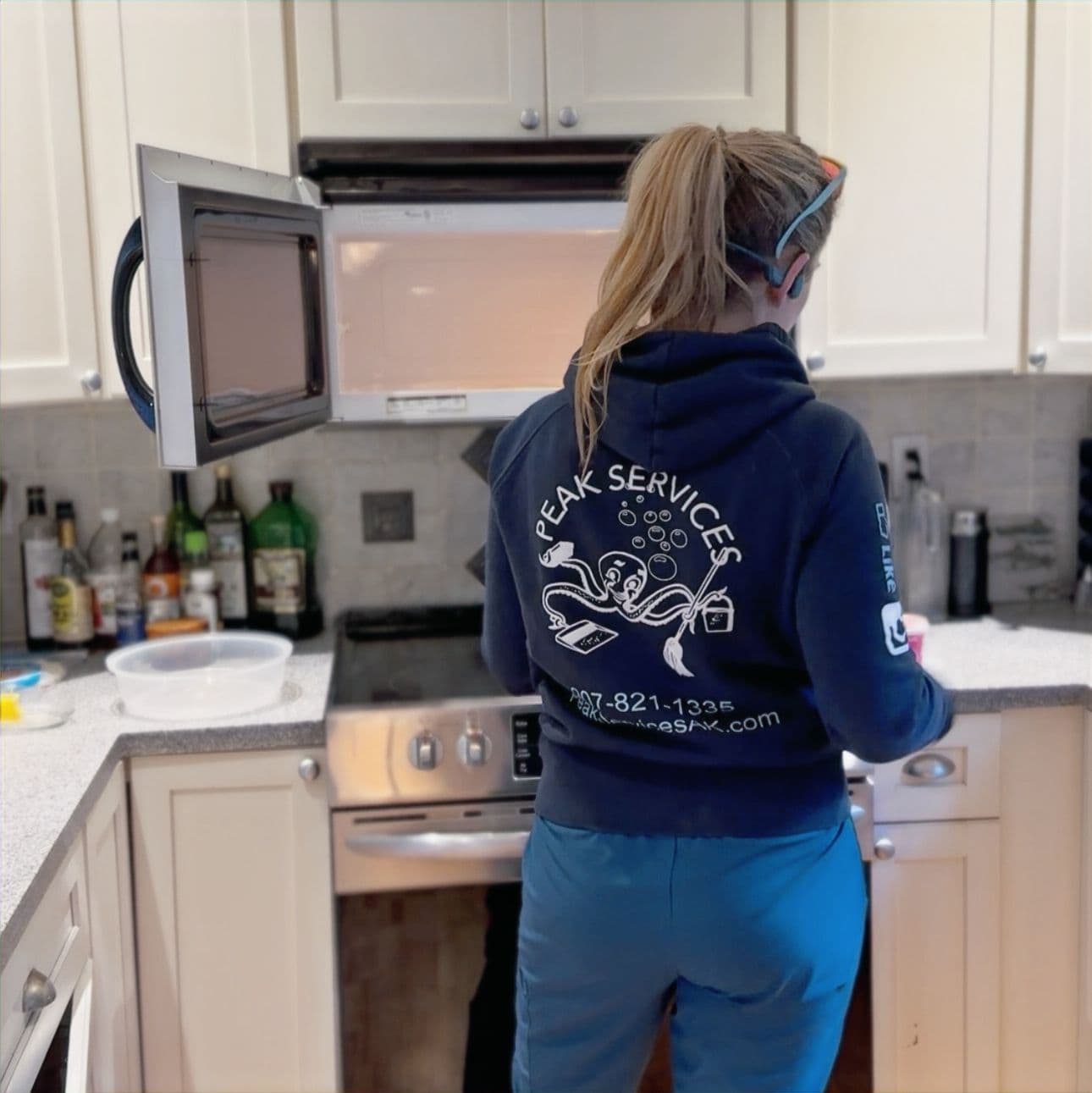 A Peak Services technician cleaning a kitchen in a Ketchikan home